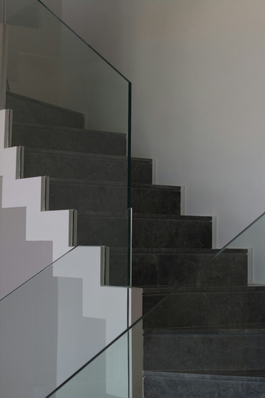 A staircase with glass panels for banisters.